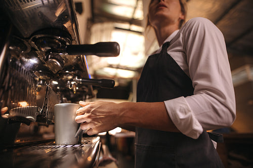 Barista making coffee on coffee maker machine