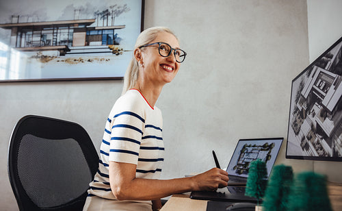 Senior female architect working at desk in modern design office