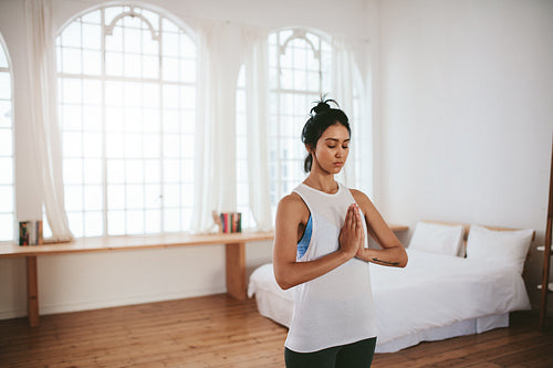 Healthy female meditating at home