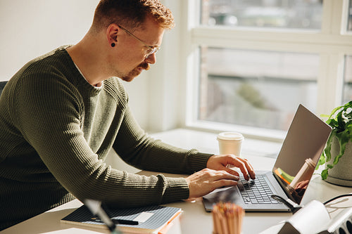 Male executive working on laptop in office