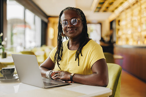 Confident businesswoman working in a cafe