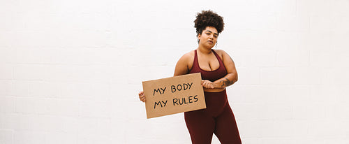 Woman holding banner of "My body my rules"
