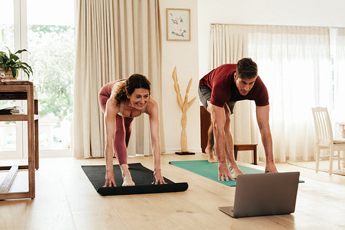 Couple exercising at home watching fitness video