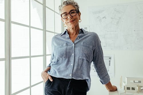 Confident in her creative expertise: Female architect looking at the camera in her office