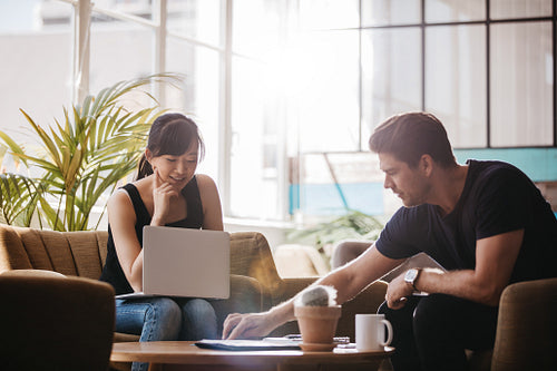 Two people working together in office lobby