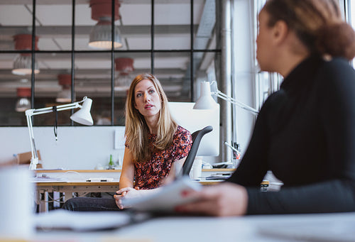 Businesswoman speaking with her colleague in office