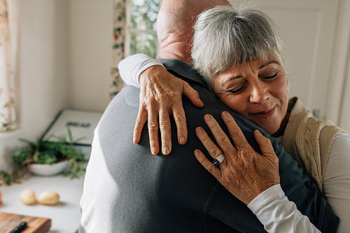 Senior couple hugging each other at home
