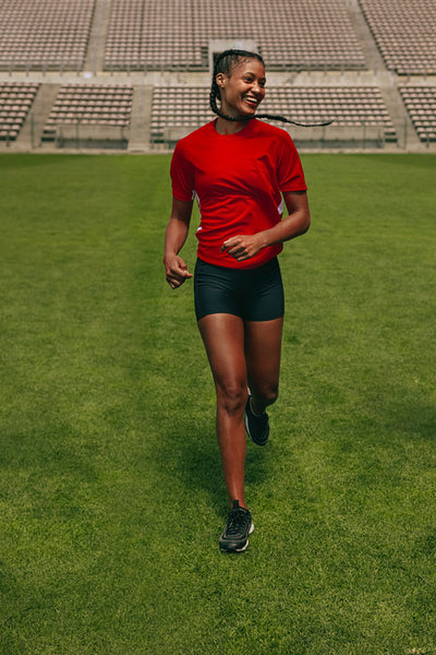 Smiling female soccer practising on the field