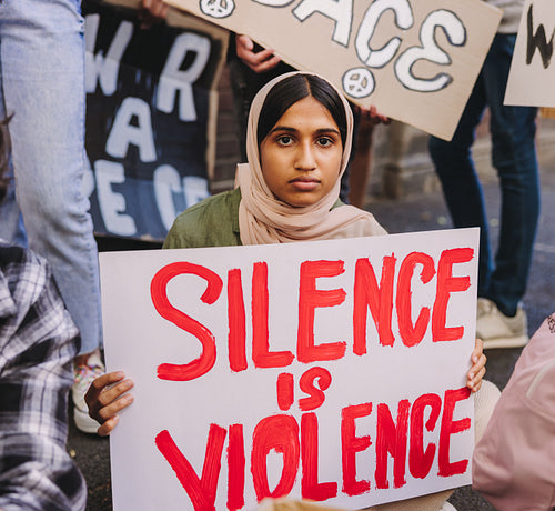 Muslim girl holding an anti-violence poster