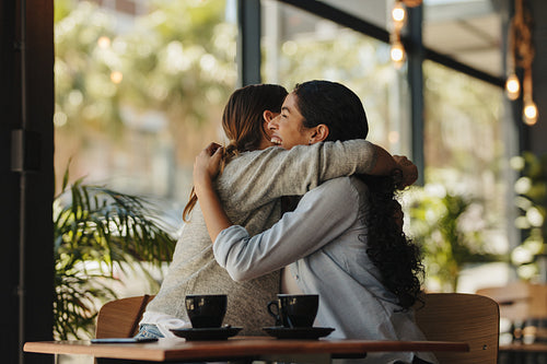 Two female friends meeting in a cafe