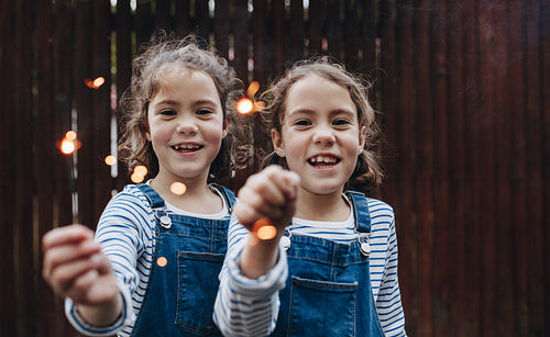 Girls joyfully holding sparklers