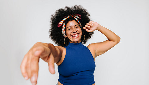 Woman with curly hair having fun in a studio