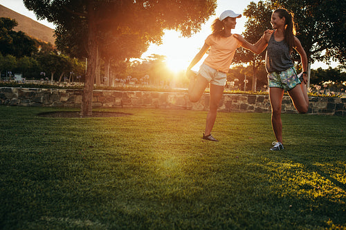 Two young women stretching at park