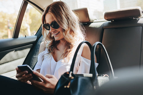 Smiling woman traveling by a car