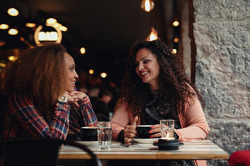 Young friends sitting in a cafe and talking