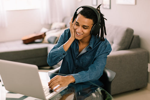 Happy young man listening to music at home