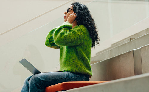 Library study finds a student using headphones on indoor steps