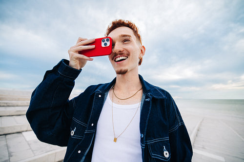 Young man taking a selfie with smartphone, smiling