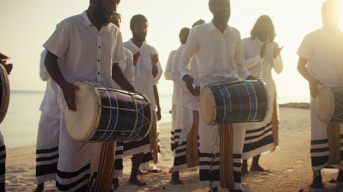 Traditional Bodu Beru drummers perform on tropical beach at sunset