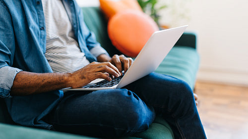 Blogger typing on a laptop in his home office