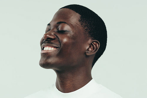 Black man celebrating his beautiful, flawless melanin skin in a studio