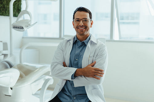 Dentist stands with a friendly smile in a modern clinic portrait