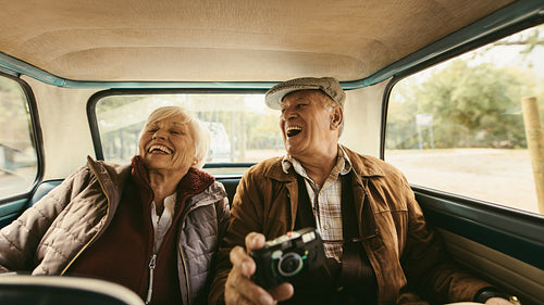 Senior couple enjoying traveling together by a car