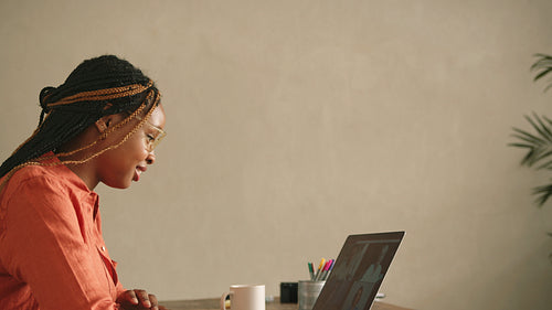 Smiling female artist greeting her clients during an online meeting