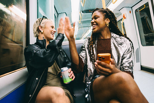 Friend celebrates with a woman on public transit