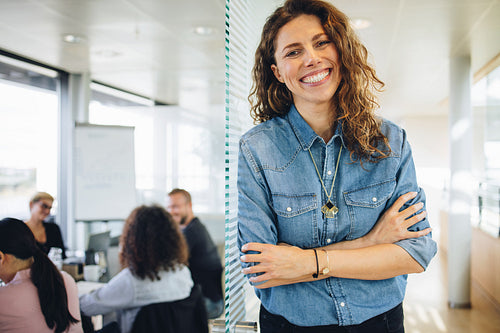 Successful businesswoman standing outside board room