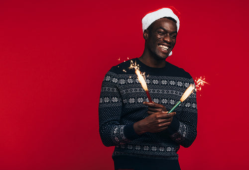 Young guy celebrating christmas with fireworks 