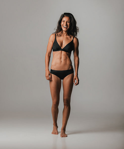 Happy vivacious young woman in black lingerie