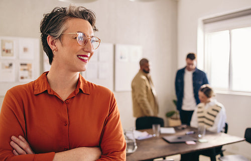 Happy mature businesswoman smiling while standing in an office