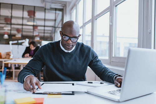 African man busy working at is desk