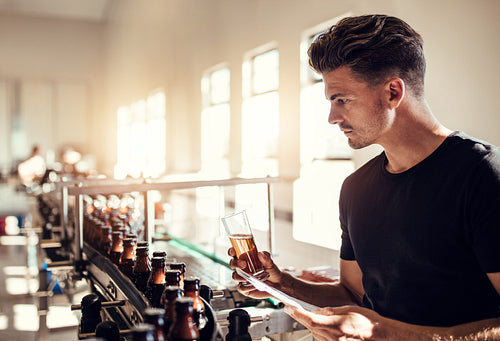 Male manufacturer testing beer in the microbrewery