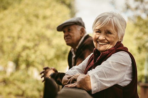 Smiling old woman at park with her husband