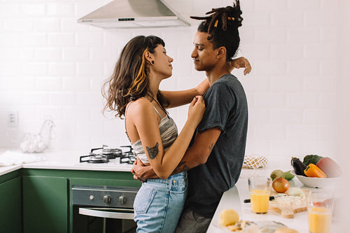 Interracial couple being romantic in the kitchen