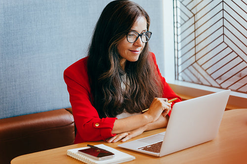 Confident businesswoman working on a laptop in a professional environment