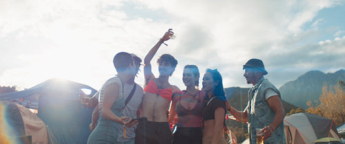 Group of gen z friends taking a selfie at a festival