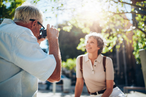 Senior man taking vacation photographs of his wife