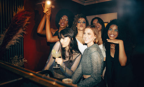 Group of friends posing for a photo in the ladies bathroom enjoying a fun night out
