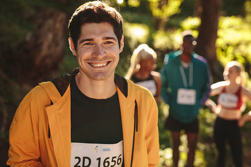 Smiling male runner standing outdoors 