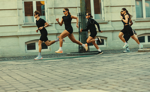 Through the city, running people push forward in a run club workout