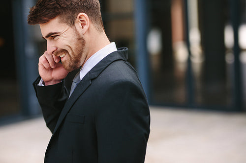 Smiling businessman talking over cell phone