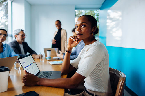 Group discussing in an office featuring a focus on a thoughtful female professional