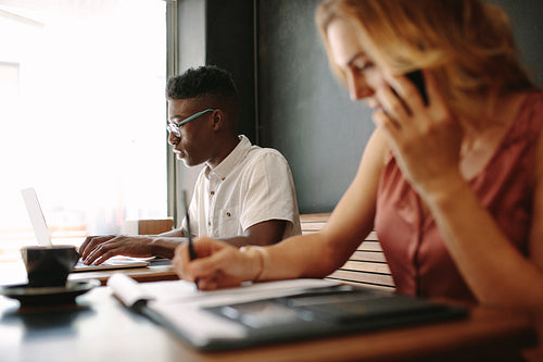 Business couple sitting at coffee shop and working