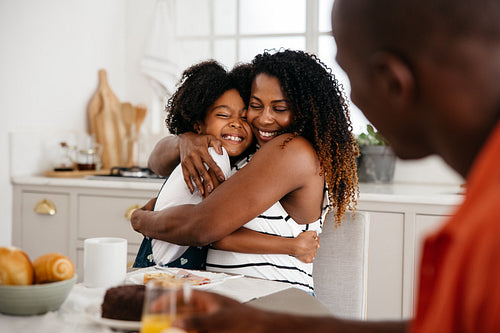 Tender Family love - Mother and daughter hug each other during breakfast
