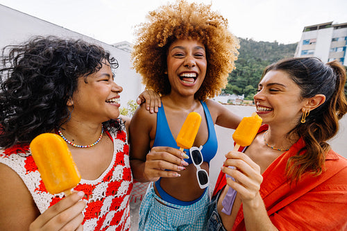 Friends enjoying popsicles outdoors on a sunny summer day in Rio de Janeiro