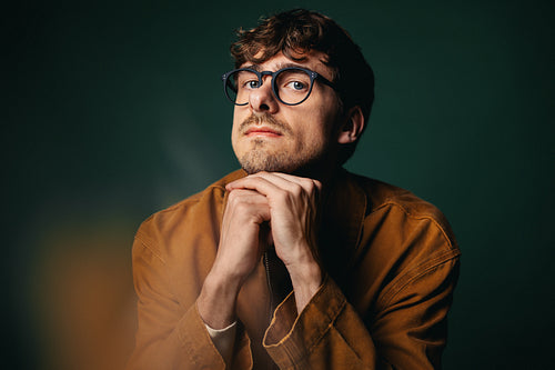 Pensive young man in glasses showing thoughtful reflection and focus