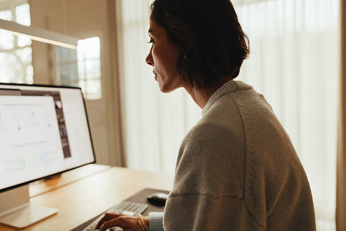 Focused woman analyzing digital documents on computer
